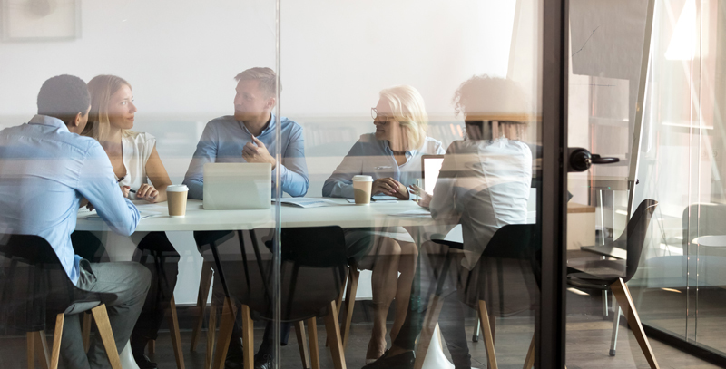 Several people sitting at a table during a meeting